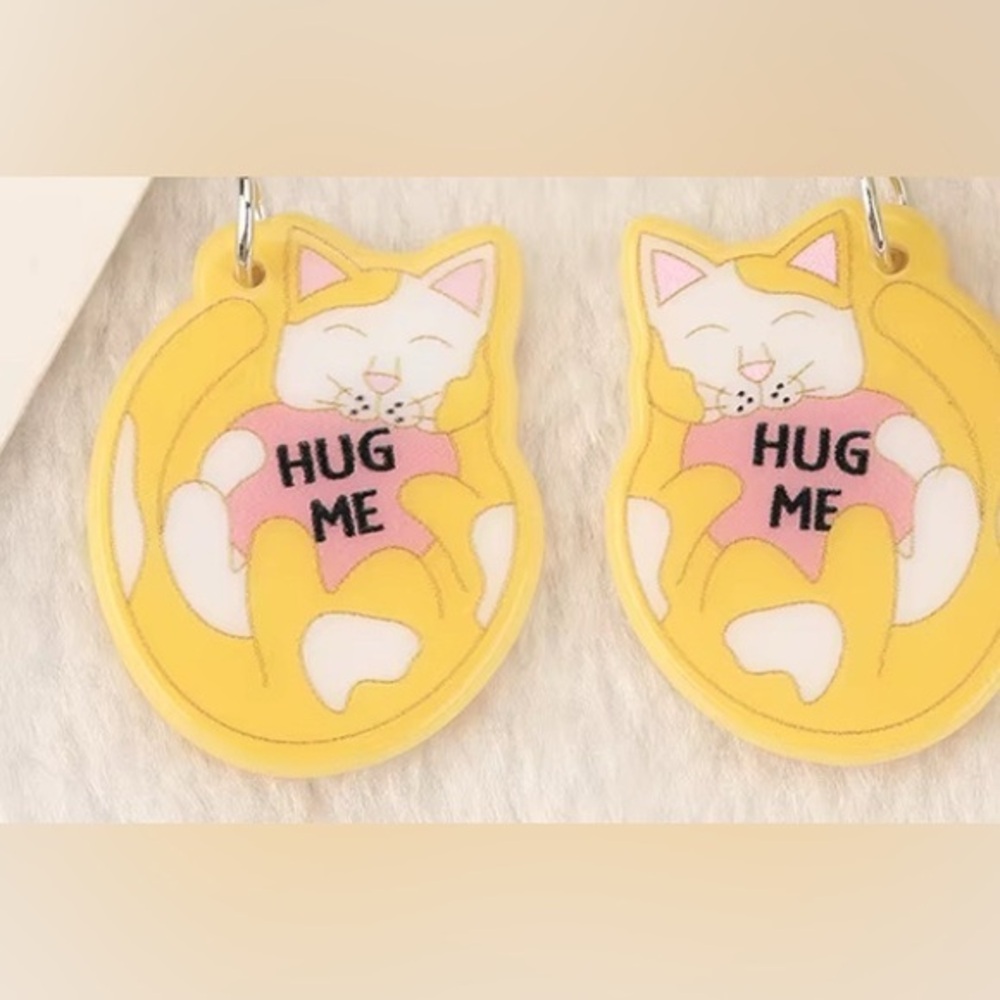 NWT - Yellow & white cat eating a “hug me” heart candy dangle earrings set